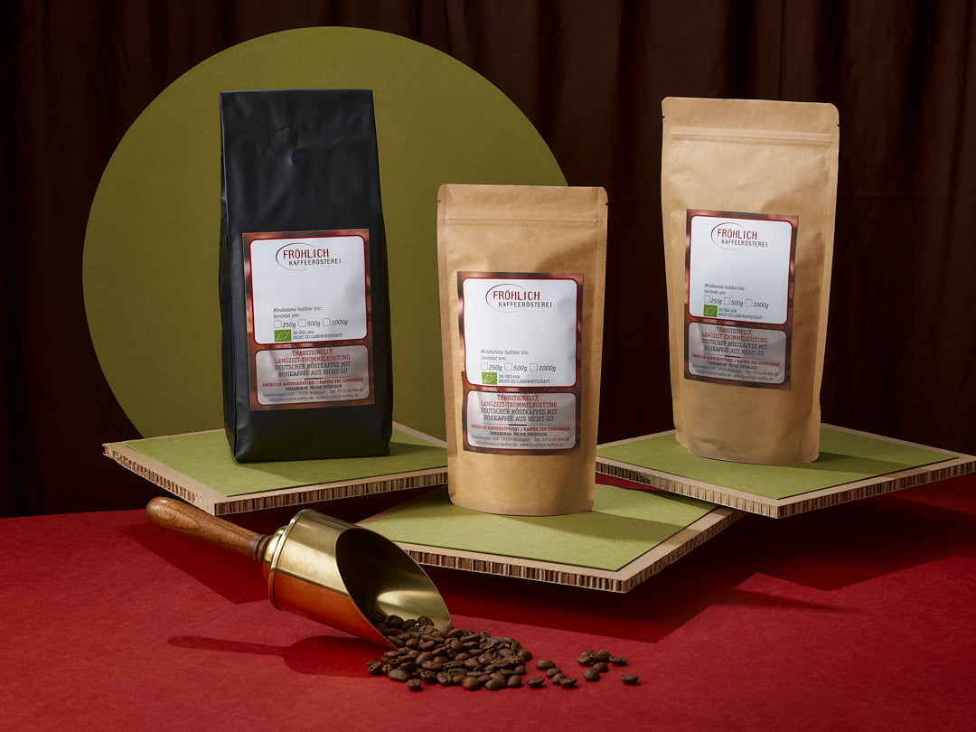Kaffee-Einschweißbeutel in unterschiedlichen Größen mit messingfarbener Kaffeeschaufel und Kaffeebohnen